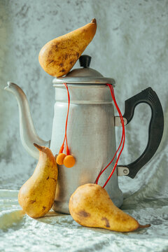 Fruits and kettle placed on a table for a still life scene