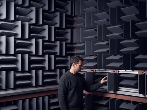 Male Audio Engineer Inspecting Soundproofing Wedges Inside an Anechoic Testing Chamber