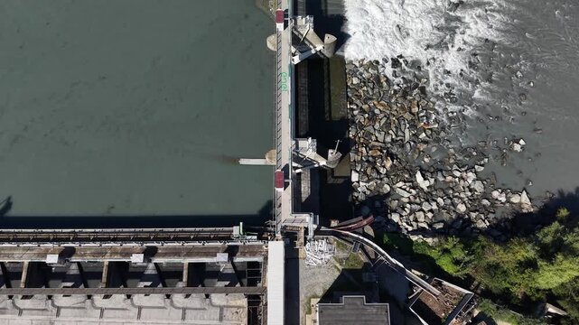 Aerial view of the concrete dam and flowing water on the Po River in San Mauro Torinese, Piedmont, Italy.