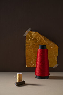 Red Thread Spool and Supplies a textured brown background