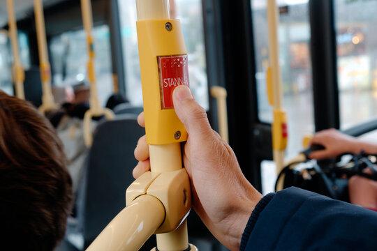 a man presses the stop-request button on a Swedish city bus