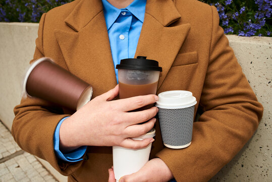 Holding multiple cups of coffee in the park