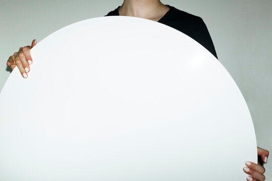 Person holding geometry rounded shape sign with empty space for text