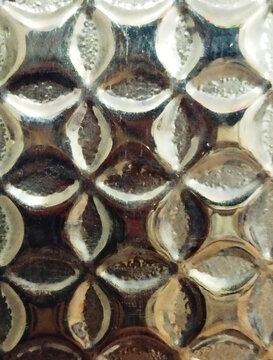 Close-up of intricate geometric glass mosaic with reflective metallic patterns and hexagonal shapes