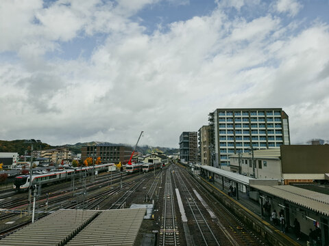 Takayama, Gifu, Japan - 01 September 2026: View of Takayama Station with multiple train tracks, modern buildings, and a cloudy sky in the background.