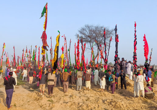 Okara, Pakistan - 13 March 2024: View of the annual Urs and mela at the shrine of Sufi saint Hazrat Daud Bandagi Kirmani, featuring devotees gathered with colorful ceremonial flags.