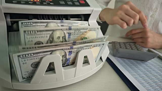 Counting cash with a money counter at a financial office in the afternoon