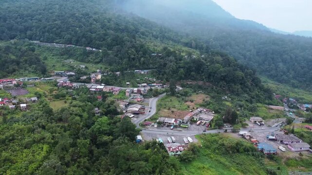 Aerial view of the town of Berastagi nestled among lush green mountains and dense forests in Berastagi, North Sumatra, Indonesia.