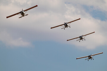 Fototapeta premium Group of ViS-3 KhAZ-30 ultralight ukrainian planes flying in group stunt on airshow in cloudy sky