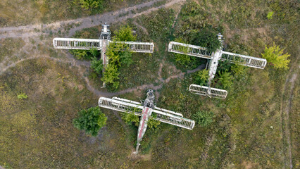 Abandoned old aircrafts rusting in overgrown airfield, look down aerial view © Kathrine Andi