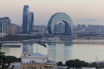 Fototapeta premium Glistening skyline of Baku at sunset with modern architecture and vibrant national flag
