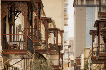 Fototapeta premium Intricate wooden balconies grace the streets of Baku, blending history with modernity's skyline