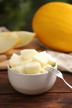 Slices of fresh sweet melon on wooden table outdoors, closeup