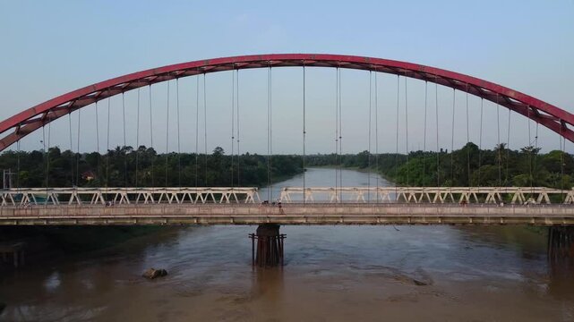 Aerial view of Wampu River Bridge Binjai - Langsa Toll Road spanning the river with lush greenery in Stabat, North Sumatra, Indonesia.