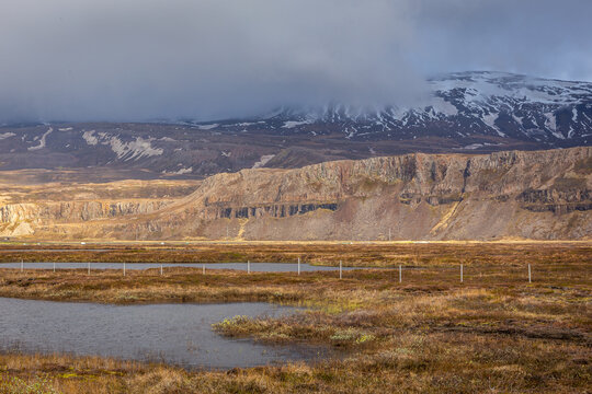 Snowcapped mountain range over wetland marsh near Egilsstadir Iceland