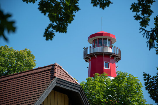 Newly painted red and white lighthouse in midday sunlight.