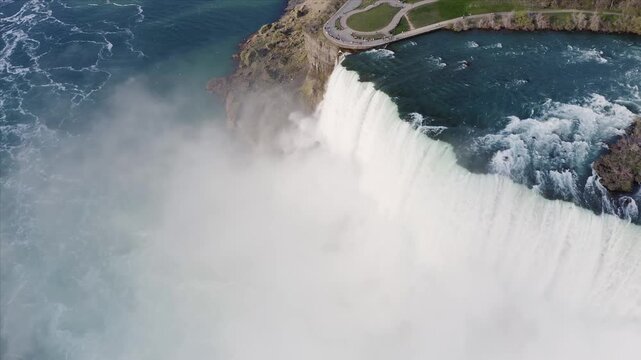 Aerial view of the powerful Niagara Falls with mist rising from the cascading water and surrounding parkland in Niagara Falls, Ontario, Canada.