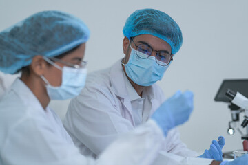 A research scientist inspects a laboratory sample with focus in a bright white research studio...