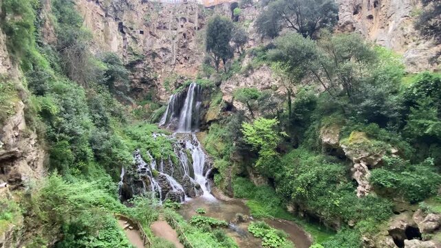 Scenic view of powerful stone rocks and cascade overgrown with moss and greenery, cultural national park in the city of Tivoli, famous sightseeing with historical value