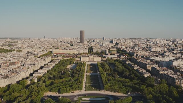 Panoramic high-angle view of Champ de Mars park leading to the Ecole Militaire and Tour Montparnasse skyscraper in the distant skyline, shot from the Eiffel Tower in Paris. High quality 4K video