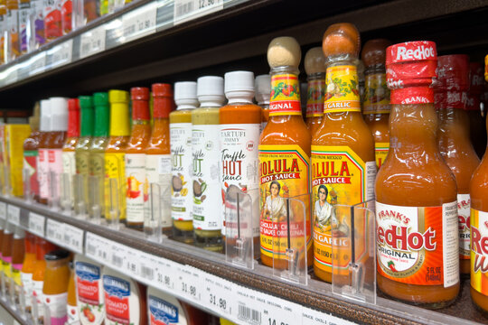 PENANG, MALAYSIA - JUL 03, 2026: Assorted Cholula, Frank's RedHot and truffle hot sauces displayed on supermarket shelf.
