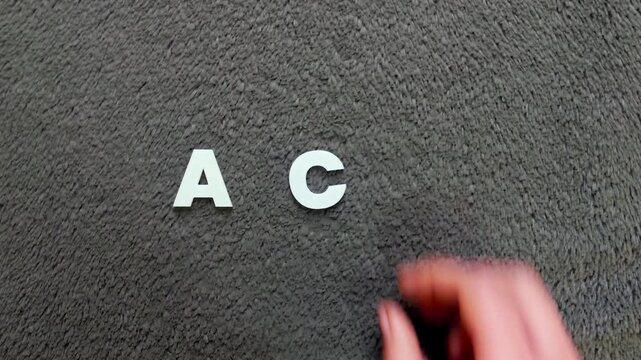 persona escribiendo la palabra acv en un fondo texturizado y oscuro con letras blancas y pre hechas (version rapida)