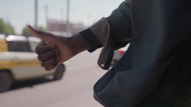 Close up of person holding and examining crumpled paper with faint markings possibly outdoors on street. person manipulates material while wearing casual clothing including dark jacket