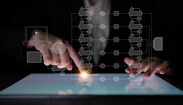 Business professional analyzing digital interface with flowchart diagrams on a tablet, representing technology and data management in modern work environments. Quark.