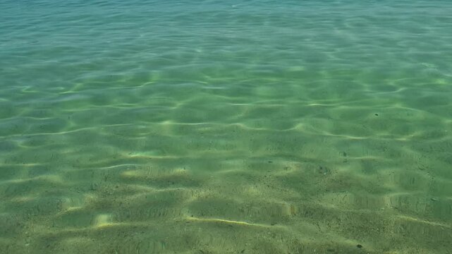 Clear turquoise water gently laps sandy beach. Trani Ammouda, Greece