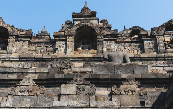 Ancient Headless Buddha Statue and Carved Niches on the Stone Terraces of Borobudur Temple in Central Java Indonesia