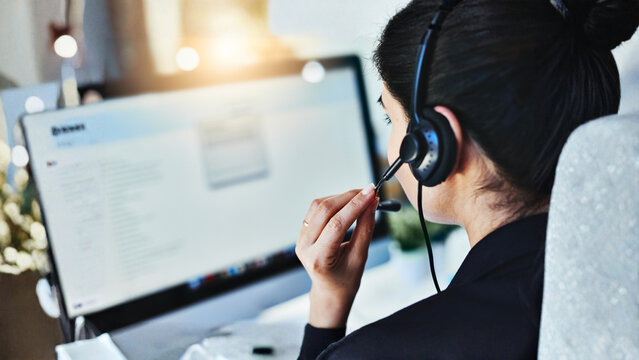 Female Call Center Agent Wearing Headset and Working on Computer Screen View From Behind