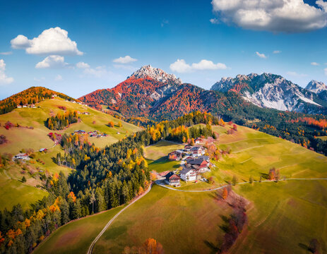 Sunny Autumn view from flying drone of San Vigilio di Marebbe village, Province of Bolzano, South Tyrol, Italy, Europe. Aerial afternoon scene of Dolomite Alps. 