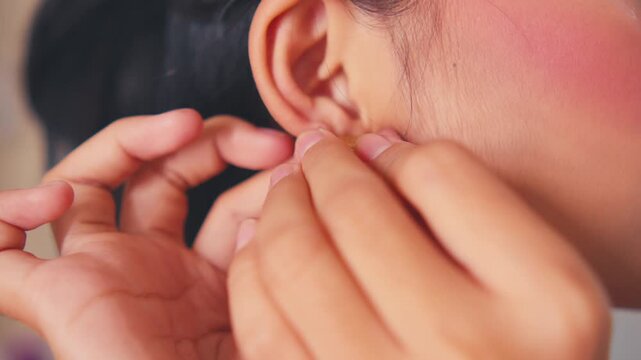 Putting On Large Gold Textured Hoop Earring (Extreme Close-up)