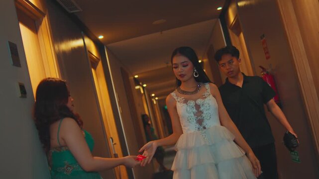 Woman Accepts Condom from Assistant in Hotel Hallway