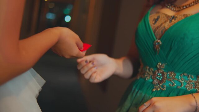 Woman Receiving a Condom Packet from Friend in Hotel Hallway