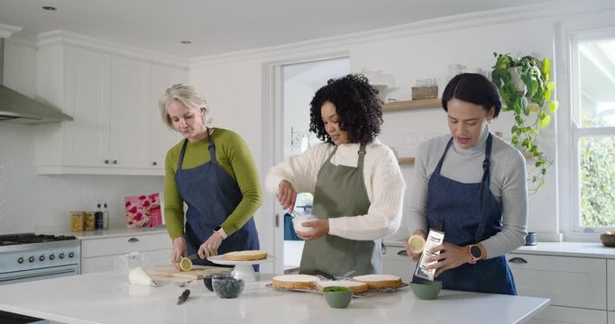Diverse female friends planning to bake cake at white kitchen island, slicing lemons and frosting