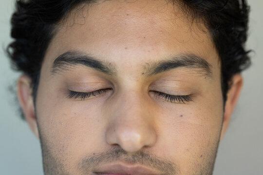Adult African male resting with closed eyes in studio portrait showing natural skin texture