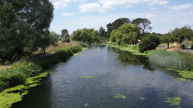 Exeter Canal, South Devon, England: DRONE VIEWS: 1. Exeter Ship Canal and paddleboarders; 2. Reveal shot of Marsh Barton industrial estate and Exeter in the distance. Exeter is a cathedral city.