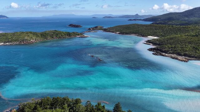 Aerial view of Mushroom Beach near Whitehaven Beach with turquoise waters blurred with coral spawning, and lush vegetation, Whitsunday Islands, Queensland, Australia.
