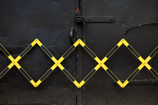 Black door with yellow cross pattern gate
