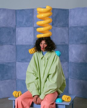 Wacky pomo surreal portrait of a woman with a glossy yellow coiled spring on her head, featuring vibrant colors for creative posters and art