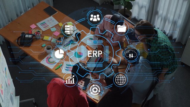 Collaborative Team Meeting with Business Graphics and ERP System Integration Over a Table with Papers and Laptops in Modern Office Environment. Entropy.