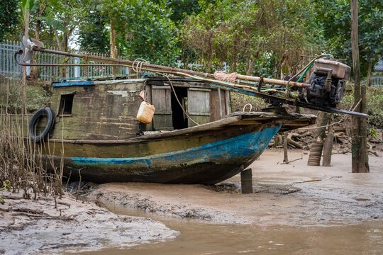 Traditionelles Holzboot am schlammigen Ufer im Mekongdelta