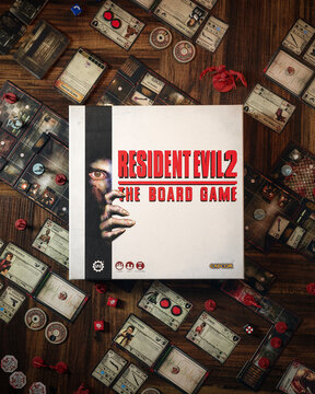 Resident Evil 2 board game components close up featuring zombie miniatures survival horror cards game board custom dice and box cinematic dramatic lighting tabletop game layout for hobby recreation