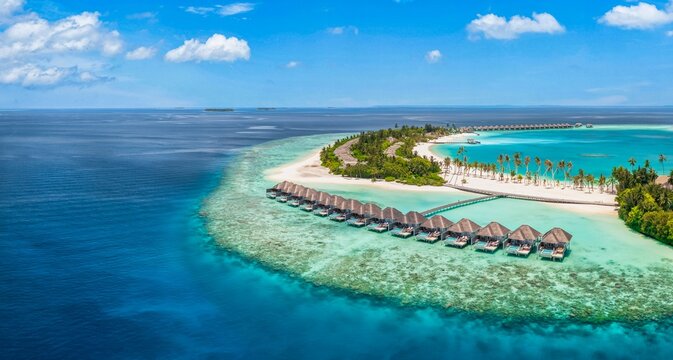 Stunning aerial Maldives overwater villas turquoise lagoon tropical island coral reef summer vacation resort. Peaceful summer beach nature seascape. Luxury honeymoon holiday drone travel scenic view
