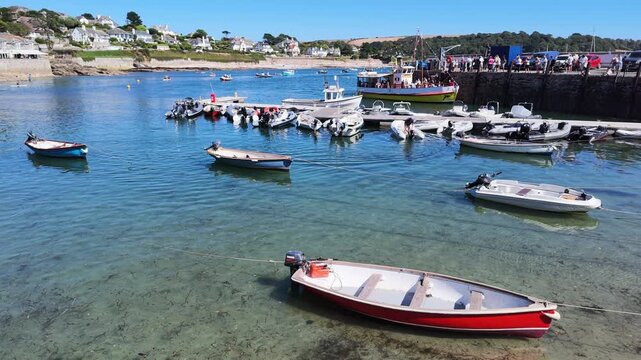 St Mawes Cornwall England UK. 13.08.2026. Video. St Mawes a popular Cornish resort at low low tide  and a passenger ferry alongside the harbour wall with waiting passengers.