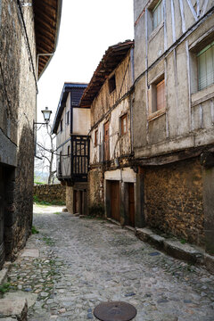 Narrow street with Typical houses with granite stone plinths and upper floors with geometric wooden frameworks in La Alberca town