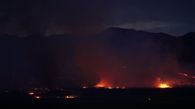 Smoke rising from the Tom Creek wildfire burning in the Utah desert at dusk.