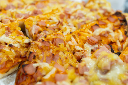 Pizza slices with ham, cheese, and onion toppings