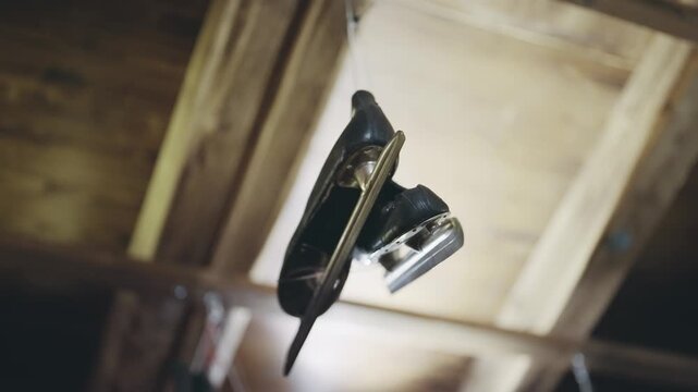 A pair of vintage black ice skates hangs suspended as a unique decoration above a festive Christmas market stand